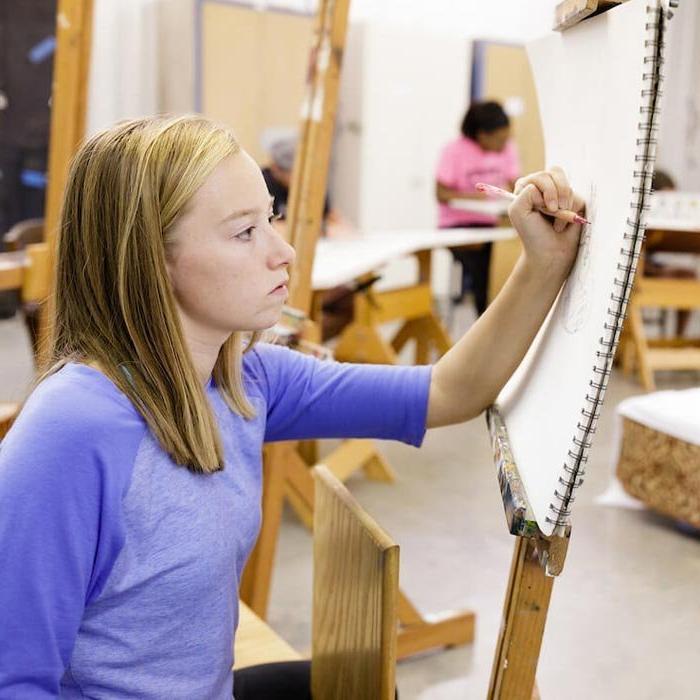 Student working on canvas in art class